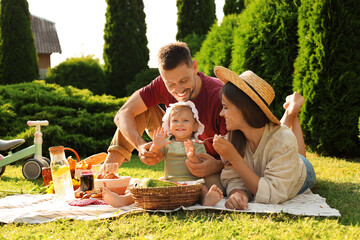 Happy family having picnic in garden on sunny day