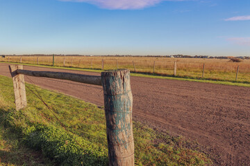 rural fence in field with distant outer suburban housing estates in the background