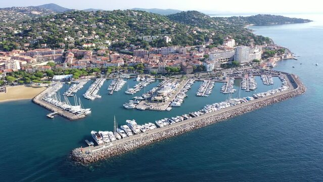 Aerial panoramic view of French commune of Sainte-Maxime on shore of Gulf of Saint-Tropez overlooking large marina on sunny summer day, Var department
