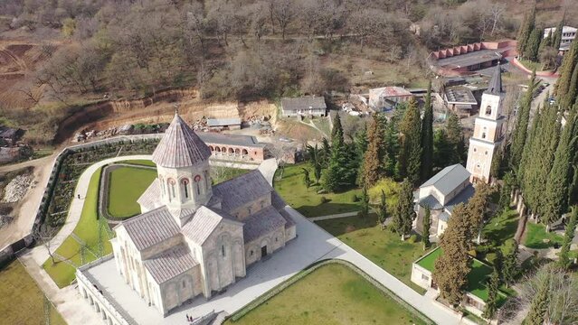 Scenic spring aerial view of Church of St. Nino in monastic complex of Bodbe nunnery on hillside overlooking Alazani Valley and Greater Caucasus mountains in background, Sighnaghi, Kakheti, Georgia