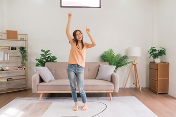 Leisure activities concept, Young woman wears headphone listening music and dancing in living room