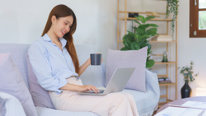 Remote business concept, Businesswoman is reading marketing plan data on laptop and drinking coffee
