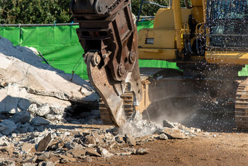 Demolition machine for crushing concrete foundation slabs, demolition site, construction industry