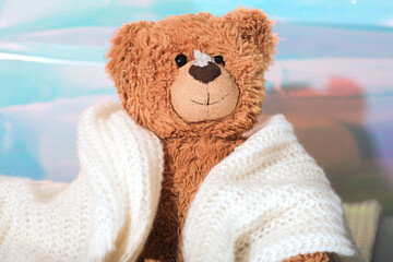 teddy bear wrapped in warm scarf with snow on a nose. energy crisis in Europe, gas and utility bills rise. cold in schools and kindergardens. electricity expenses.
