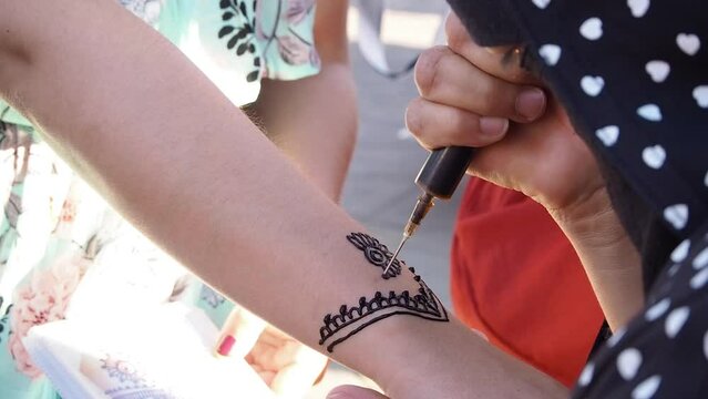 4K Footage of a traditional henna tatoo being done in the streets of Marrakesh