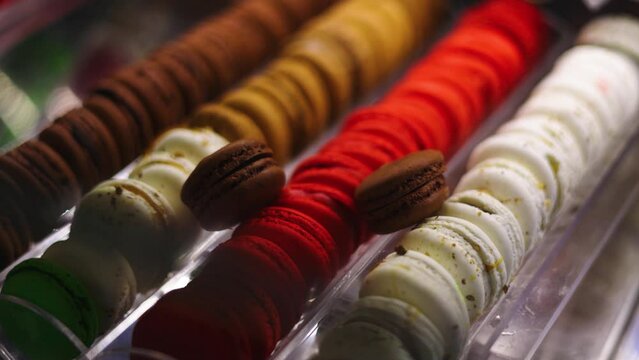 Assorted French macarons with the most popular flavor, chocolate, stacked on top