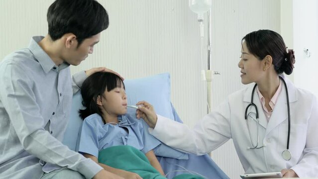 Doctor examining temperature of kid girl. Asian doctor visit patient little girl and suggest physical examination at hospital.