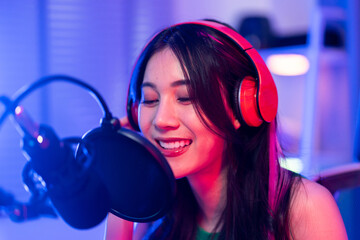 Asian young audio DJ woman sing a song on microphone to broadcasting