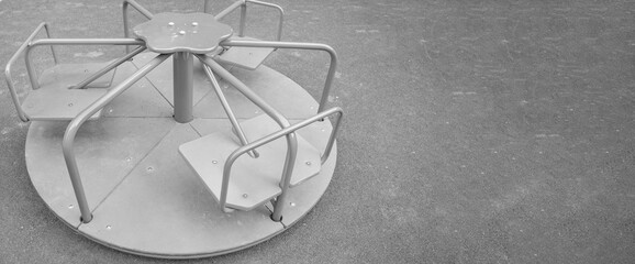 Steel round carousel on the playground, copy of the space on the right, monochrome