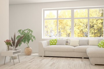 Obraz na płótnie Canvas Stylish room in white color with sofa and autumn landscape in window. Scandinavian interior design. 3D illustration