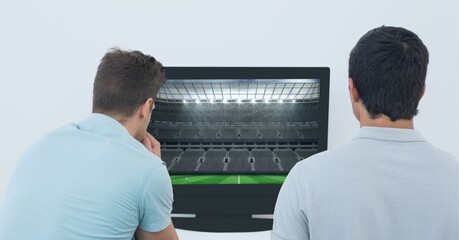 Composition of two male sports fans watching sports stadium on tv