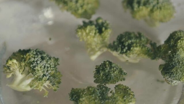 Pieces of broccoli fall into the water and float