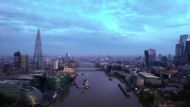 Aerial View Of Famous London Skyline Along River Thames In Blue Late Afternoon. Slow Dolly Forward
