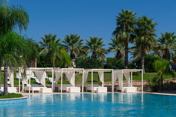 Vista piscina con letti a baldacchino