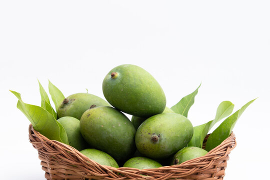 Fresh Green Raw Mango Also Called Aam, Kairi In Tradition Indian Wooden Basket Has Multiple Health Benefits, Is Rich Source Of Vitamins. Used For Chutney, Khatta Aam Panna And Aam Ka Achar Pickle