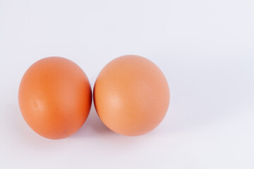 two eggs are placed on a white background with free space on right