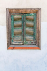 Old wooden window with closed lattice shutters. Vertical.