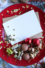 christmas greeting card mockup. fir branches with Christmas decorations and an envelope with a white blank for text	