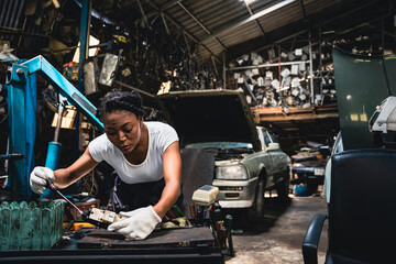Fototapeta na wymiar Female mechanic is repairing the parts of the car so that it can be used.