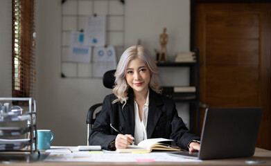 Portrait charming asian businesswoman sitting working on laptop computer at home office