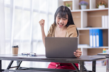 Overjoyed senior adult business Asian woman is using laptop, receive good news. Excited young entrepreneur got promotion on work or have done successful project, enjoy own results