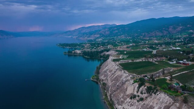 Vineyard with rows of wine grapes hyper lapse with storm background, Okanagan Valley, aerial drone footage, fields, lush valley, mountains, desert, British Columbia, Canada. 4K 4096x2304 PRORES 24FPS.