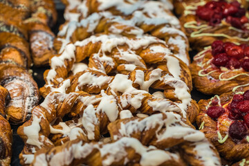Abstract image of sweet pastries, background. Side view from above. Beautiful delicious fillings, bright, colorful pastry cakes, sweets with fresh strawberries and fudge.