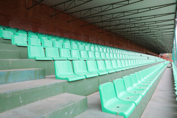 New sports stadium in the open air, green stands. Empty seats in the stadium.