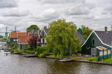 Obraz premium Rural landscape with windmill in Zaanse Schans. Holland, Netherlands. Authentic Zaandam mill. Beautiful Netherland landscape.