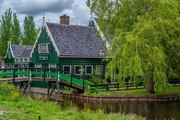 Fototapeta na wymiar Rural landscape with windmill in Zaanse Schans. Holland, Netherlands. Authentic Zaandam mill. Beautiful Netherland landscape.