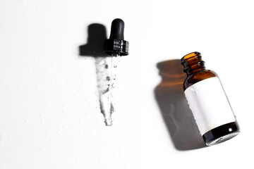 Top view of cpsmetic dropper bottle with black pipette on white podium.B eauty Cometic product, oil...