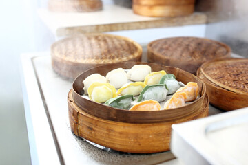 Traditional Chinese dumplings in a bamboo steamer basket. Cooking colorful dim sum on steam.