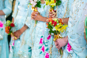 Indian bridesmaids' hands holding flowers close up