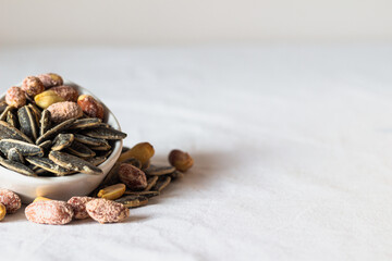 Roasted salted peanuts and roasted salted sunflower seeds. Close-up. Nuts. Eaten.