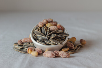 Roasted salted peanuts and roasted salted sunflower seeds. Close-up. Nuts. Eaten.