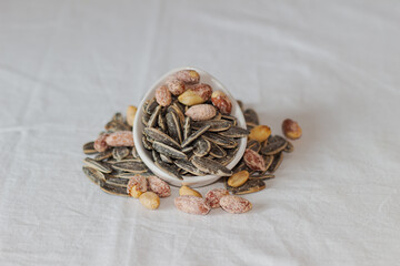 Roasted salted peanuts and roasted salted sunflower seeds. Close-up. Nuts. Eaten.