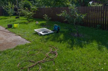 In the garden, various household items are visible on the grass