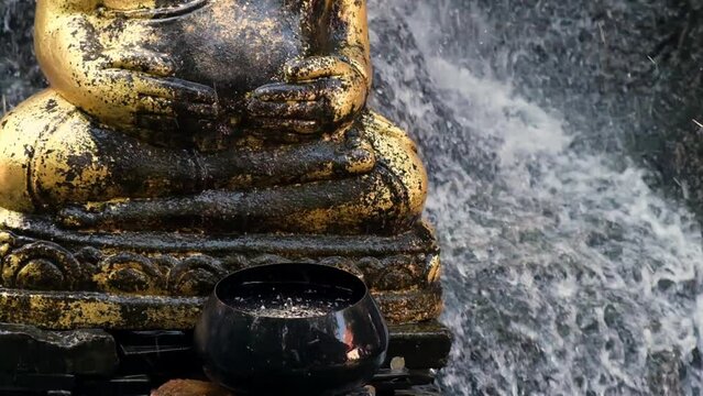 Cross-legged Fat Golden Buddha's stature is surrounded by floating water, lotus posture, in slow-motion, brings peacefulness and calm feeling, High-quality FullHD footage