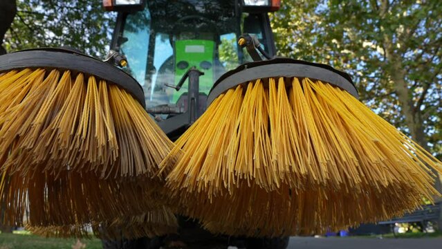 4k video with a street cleaning equipment. Closeup view of nylon brush of a road sweeper parked in the sidewalk. City management industry. 