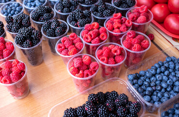 Berries raspberries and blackberries on the counter in the market.