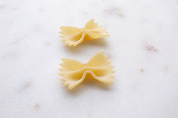 small composition of durum wheat pasta on white marble background