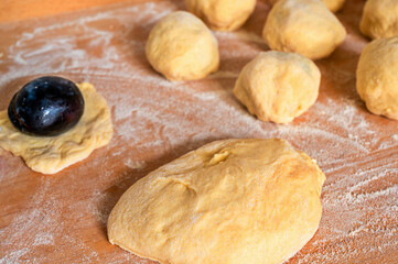 Preparation of sweet plum dumpling on wooden kitchen board.