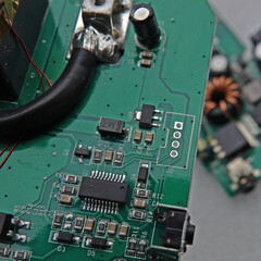 Macro photo of an electronic circuit board of a portable charger with selective focus. A second...