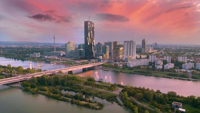Vienna Austria skyline aerial view, vienna skyscrapers river and bridge drone footage in 4k at sunset colored sky.