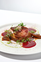 Baked camembert in parma ham on brioche with berry jam. Elegant food - hot appetizer of camembert and ham in summer menu. Cheese appetizer in fine dining. Summer menu.