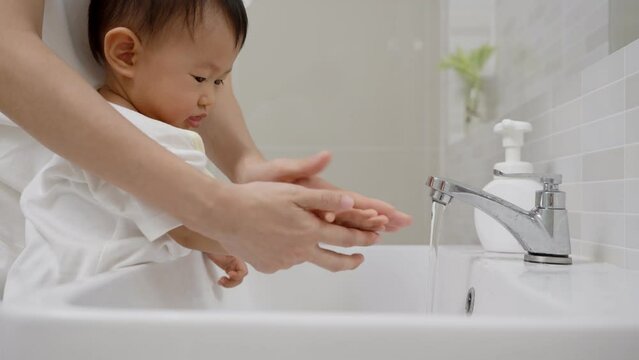 Mother practice Toddler washing his hands after handling an object to prevent infection with the virus. Washing your hands frequently dispose virus.concept for prevent germs and virus