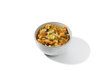 Fried rice with egg, chicken and vegetables isolated on white background. Traditional chinese food - fried rice with chicken meat in ceramic bowl Nasi goreng with fried rice, chicken and egg