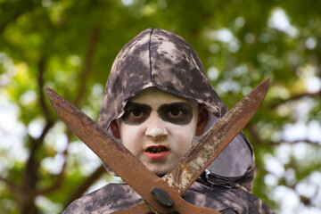 Happy halloween. Boy dressed up for halloween party holding a pair of rusty pruning shears. He is...