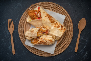 chicken and tomato in a tortilla wrap, Breakfast Wrap on wooden table background. 