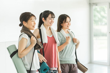 ヨガマットを持ってヨガ教室に通う日本人の女性達
